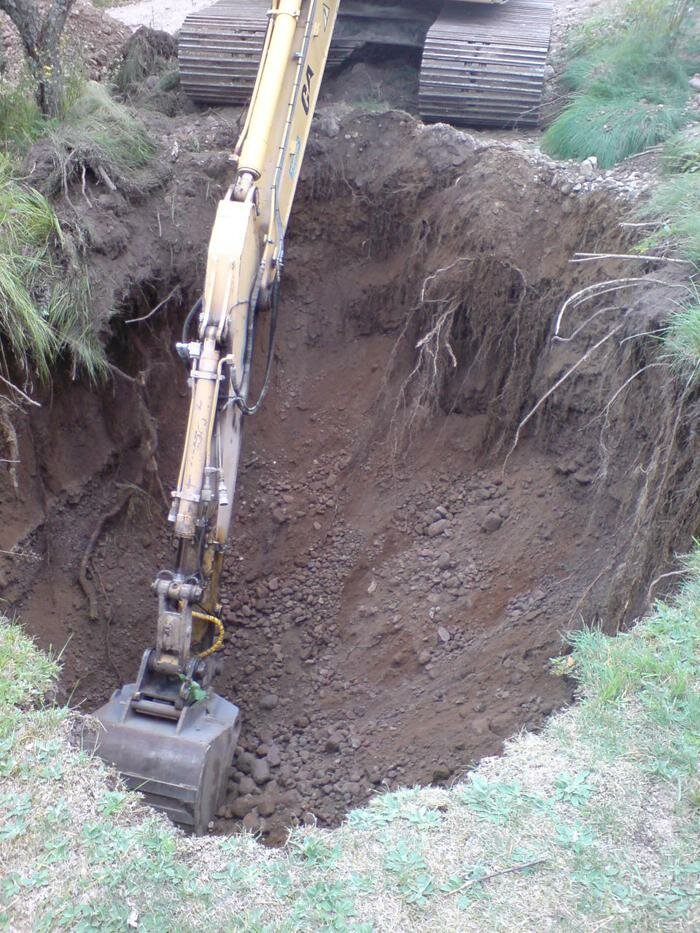 Grävskopa gräver en grop för installation av minireningsverk